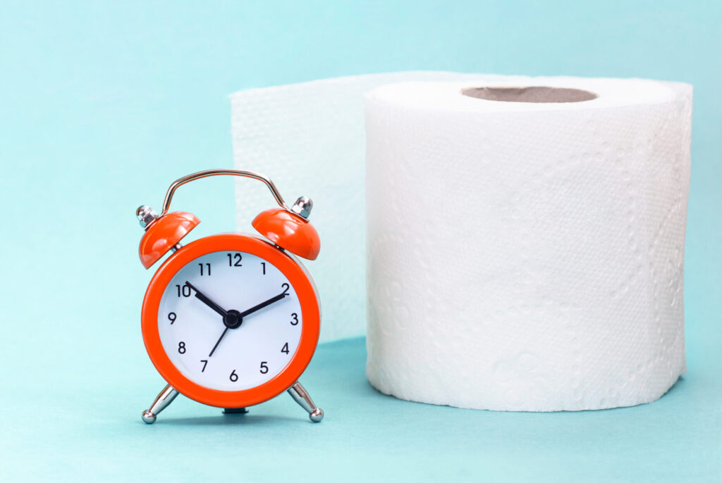 Toilet Paper with a clock beside it.