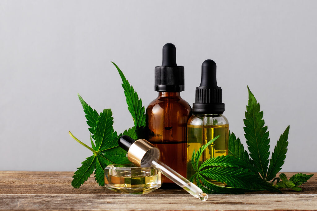 Cannabis oil in bottles on gray background